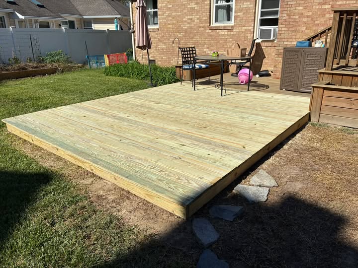 A newly built 12 by 12 wood deck in a backyard