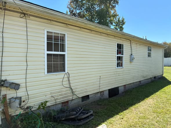 Side of a freshly washed home with a neat lawn